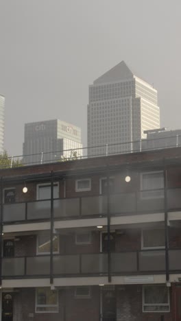 Vertical-Video-Showing-Contrast-Between-Poor-Inner-City-Housing-Development-And-Offices-Of-Wealthy-Financial-Institutions-London-Docklands-UK-4